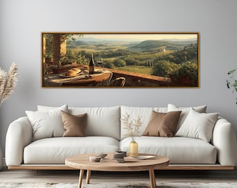 May include: A framed landscape painting depicts a Tuscan scene with a table set for a meal. A bottle of wine and a glass sit on the table, with a loaf of bread and a basket. The background shows rolling hills and a distant village.