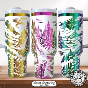 May include: Three stainless steel tumblers with white bodies and colourful fantasy landscape designs. Each tumbler features a different scene with castles, figures, and dragons. The tumblers have a white lid and a silver handle.