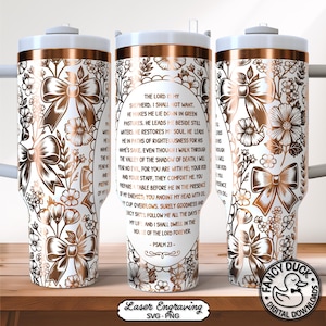 May include: A white tumbler with a copper-coloured rim and handle, featuring a floral and bow design. The text of Psalm 23 is printed on the tumbler. The tumbler has a white lid and a straw.