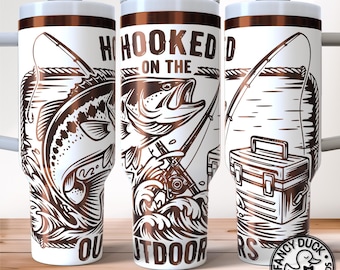 May include: White insulated tumbler with a brown fishing-themed design. The tumbler features a leaping fish, fishing rods, and the words "Hooked on the Outdoors." The design is laser engraved. The tumbler has a white lid and a brown band.