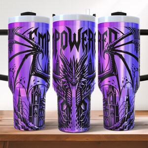 May include: Three purple insulated tumblers with a dragon and castle design. The word "EMPOWERED" is printed on the tumblers. The tumblers have a white lid and a black handle.