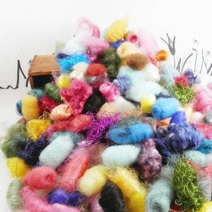 May include: A colorful pile of yarn scraps in various shades of pink, blue, green, yellow, and purple. The yarn is arranged in a loose, organic heap, creating a visually appealing and textured display.