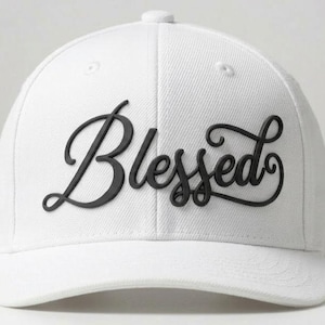 Puede incluir: Gorra de béisbol blanca con la palabra "Blessed" en letras negras en la parte delantera. La gorra tiene una visera curva y un botón en la parte superior. El texto está en una fuente cursiva.