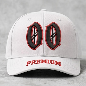 May include: A white baseball cap with the word "PREMIUM" embroidered in red on the brim. The cap features two stylized black and red "O" letters on the front.