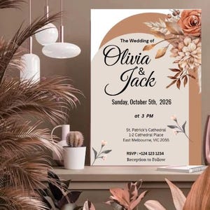 Może przedstawiać: Zaproszenie ślubne z kwiatowym wzorem w odcieniach brązu i beżu. Tekst brzmi "The Wedding of Olivia & Jack" z datą, godziną i miejscem. Elementy dekoracyjne obejmują kwiaty i liście.