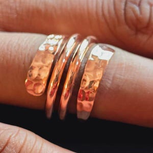 以下が含まれることがあります： ハンマー加工されたテクスチャの銅色のリング。 リングは指に何度も巻き付き、スパイラル効果を生み出します。 金属は暖かく赤みがかった茶色で、デザインはシンプルでありながら目を引きます。 リングはジュエリーです。