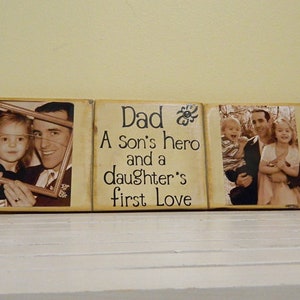 May include: A three-piece wooden sign with a photo of a father and his children. The middle piece reads "Dad A Son's hero and a daughter's first love".