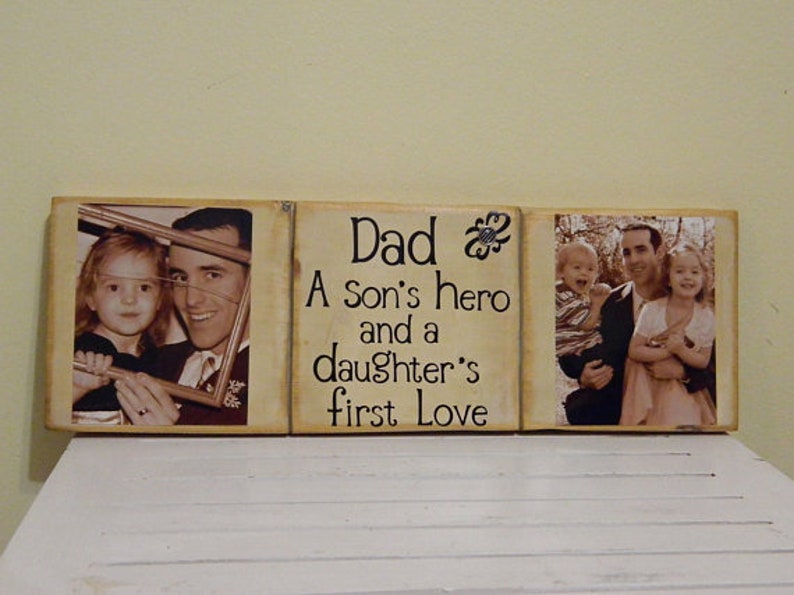 May include: A wooden sign with three panels. The center panel has the text "Dad A son's hero and a daughter's first love". The left panel has a photo of a father and daughter. The right panel has a photo of a father with two children.