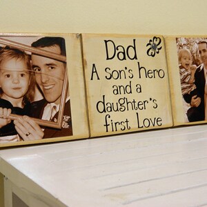May include: A wooden sign with three panels. The center panel has the text "Dad A Son's hero and a daughter's first Love". The left panel has a photo of a father and daughter. The right panel has a photo of a father and two children.
