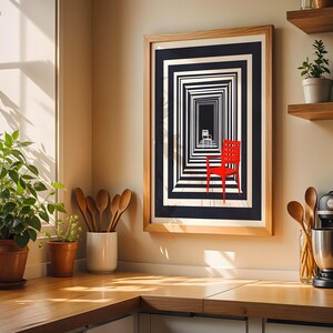 May include: A framed art print featuring a black and white geometric design with a red chair. The artwork is displayed on a light-colored wall above a wooden countertop. A potted plant and kitchen utensils are also visible.