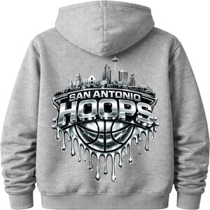 May include: A gray hoodie featuring a silver and black graphic of the San Antonio skyline and the words "SAN ANTONIO HOOPS" over a basketball. The design has a dripping effect.
