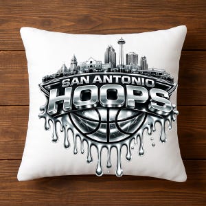 May include: White square pillow featuring a silver and black graphic. The design includes the text "SAN ANTONIO HOOPS" above a basketball and a skyline silhouette. The design has a dripping metallic effect.