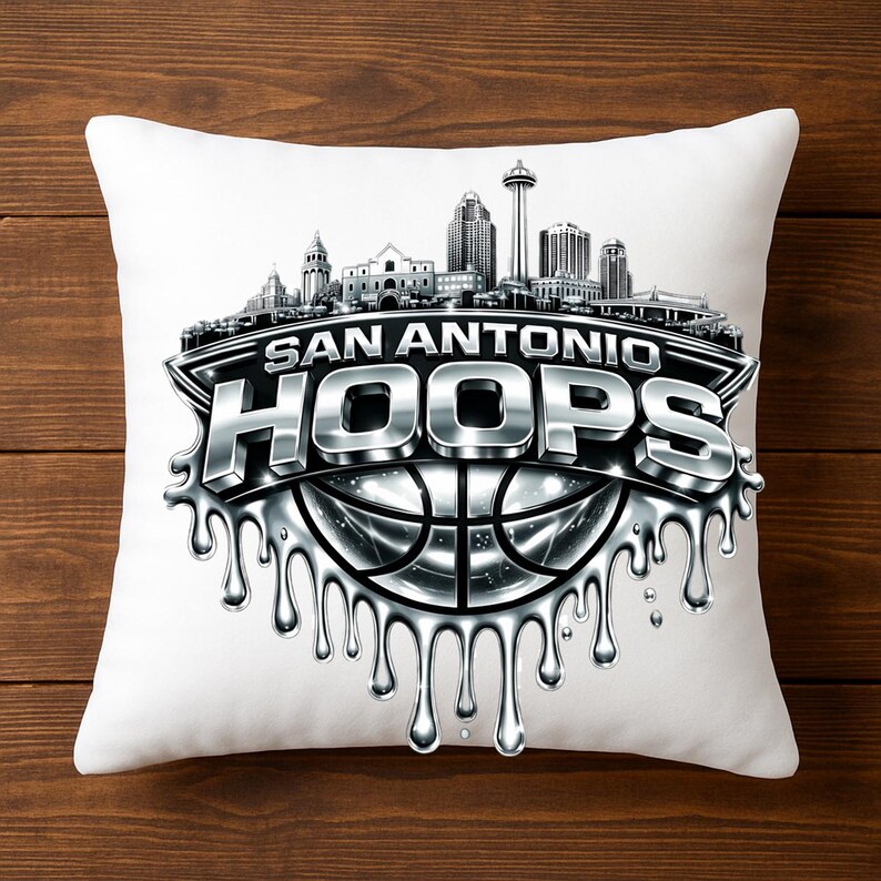 May include: White square pillow featuring a silver and black graphic. The design includes the text "SAN ANTONIO HOOPS" above a basketball and a skyline silhouette. The design has a dripping metallic effect.