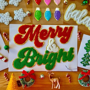 May include: A set of festive felt Christmas ornaments with a red and green "Merry & Bright" banner, white snowflakes, and a white "ho ho ho" banner.