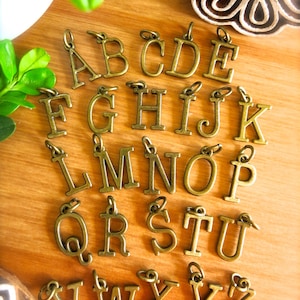 ¡Dijes del alfabeto! Elige una letra de bronce original. Collar o pulsera personalizados. Personalízalos con dijes de metal de bronce: A, B, C, escuela y colgante con nombre.