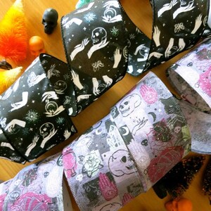 Puede incluir: Dos rollos de cinta negra y blanca con un dise&ntilde;o espeluznante y ocultista que presenta manos, calaveras y estrellas. Un tercer rollo de cinta morada y gris presenta un dise&ntilde;o similar con calaveras, manos y cristales.