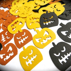 K&ouml;nnte beinhalten: Sortiment aus ausgeschnittenen Papier-K&uuml;rbisformen in Orange, Gelb und Schwarz. Die K&uuml;rbisse haben verschiedene Gesichtsausdr&uuml;cke.