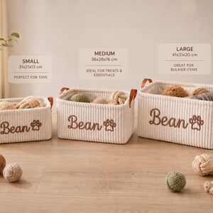 May include: Three rectangular off-white corduroy storage baskets with brown leather handles. Each basket features the embroidered name Bean and a paw print. Sizes are labeled as small 31x21x13 cm, medium 36x26x16 cm, and large 41x31x20 cm.
