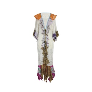 May include: A white maxi dress with a ruffled neckline and a floral print. The dress has a long, flowing skirt with a layered design. The dress is accented with orange, purple, and blue fabric.