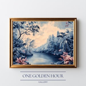 May include: A framed landscape painting with a gold-colored frame. The artwork depicts a serene river scene with blue and white tones, lush trees, and pink floral accents. The text "ONE GOLDEN HOUR GALLERY" is displayed below the frame.