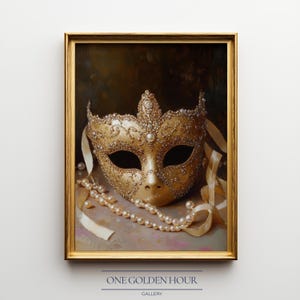 May include: A framed artwork featuring a gold masquerade mask adorned with jewels and pearls. The mask rests on a surface with a pearl necklace and ribbons. The artwork is from the "ONE GOLDEN HOUR GALLERY".