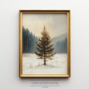 Puede incluir: Pintura de paisaje enmarcada con un pino solitario en un campo nevado, con un bosque y montañas al fondo. La obra de arte está en un marco dorado, con el texto "ONE GOLDEN HOUR GALLERY" en la parte inferior.