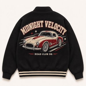 Op de afbeelding: Een zwart varsity-jack met een grote geborduurde afbeelding op de achterkant. Het ontwerp toont een rode en crèmekleurige vintage sportwagen met de tekst MIDNIGHT VELOCITY in een boog erboven en ROAD CLUB 96 eronder, geaccentueerd door kleine sterren.