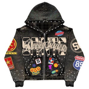 May include: Black zip-up hoodie with a distressed look, adorned with patches, rhinestones, and the text "Dirty Savage". Features a hood with glitter accents and a plaid lining. Patches include stars, a globe, and a road sign.