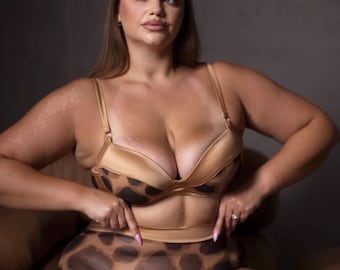 Peut inclure: Un ensemble de lingerie deux pièces composé d'un soutien-gorge à armatures en satin beige et d'une culotte taille haute. Les deux pièces présentent un motif léopard marron foncé sur les parties inférieures, tandis que le haut des bonnets est en satin uni.