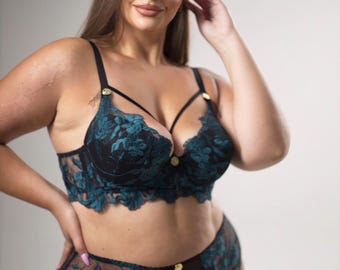 Peut inclure: Un ensemble de lingerie en dentelle florale noire et bleu sarcelle composé d'un soutien-gorge corbeille avec des bretelles fines et des détails dorés, assorti d'une culotte taille haute en dentelle transparente avec bordure festonnée.