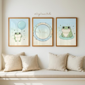 Könnte beinhalten: Drei gerahmte Kunstdrucke mit Cartoon-Fröschen. Einer hält einen blauen Ballon, ein anderer befindet sich in einem kreisförmigen Rahmen mit dem Wort "Name", und der dritte sitzt auf einem Seerosenblatt. Die Rahmen sind aus Holz.
