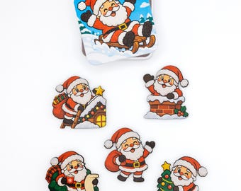 May include: A set of six wooden Santa Claus ornaments featuring various festive scenes including Santa on a sled, climbing a roof, in a chimney, sitting in a chair, standing with a sack, and decorating a Christmas tree with colorful lights.