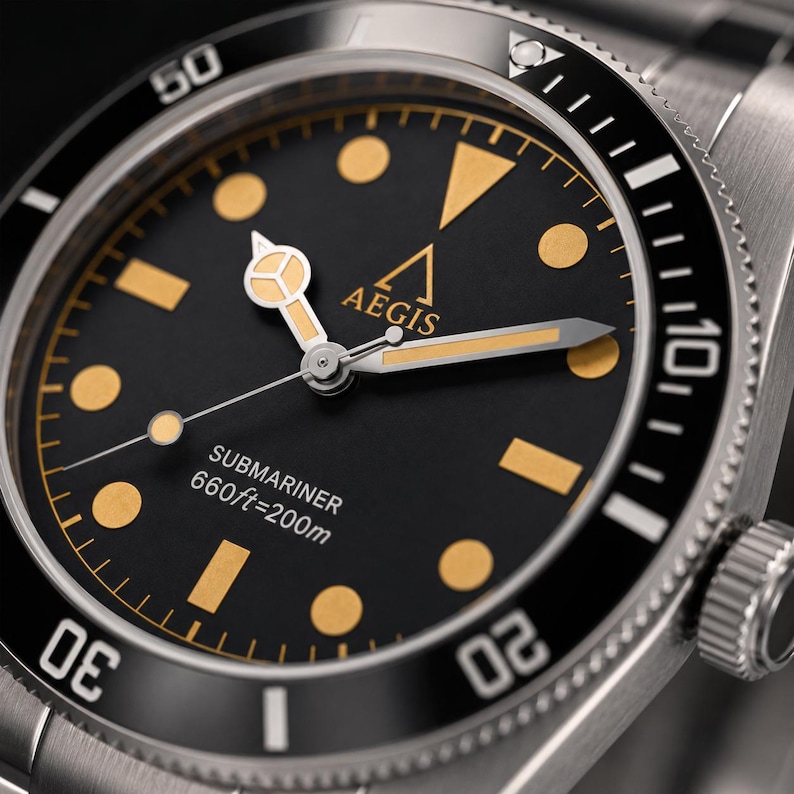 May include: A stainless steel wristwatch with a black dial, gold-toned circular and rectangular hour markers, and gold-toned hands. The dial features the text AEGIS, SUBMARINER, and 660ft=200m. It has a black rotating bezel with white numerals.