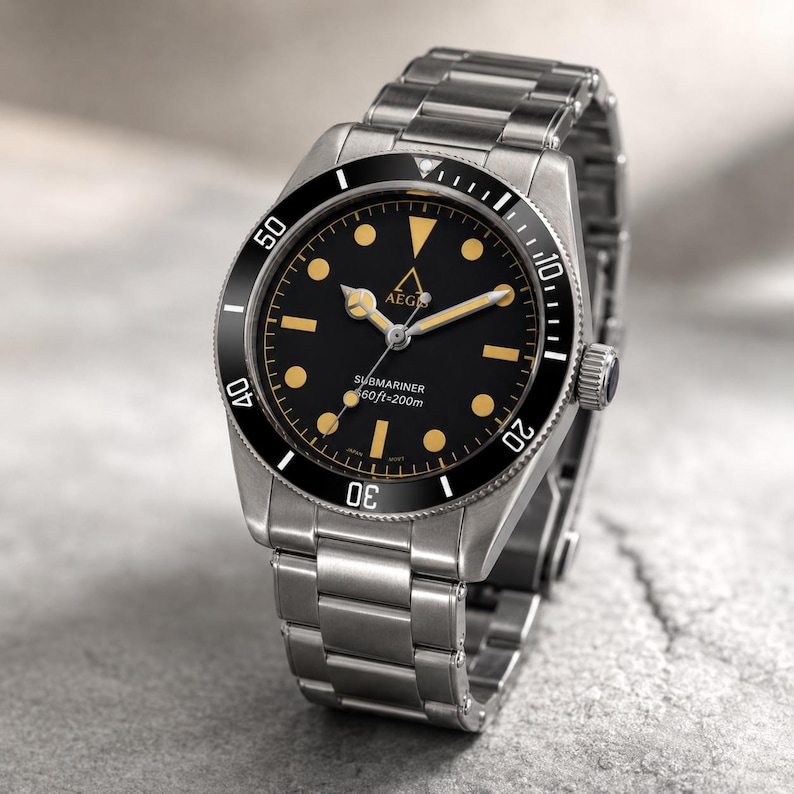 May include: A stainless steel wristwatch with a black dial, featuring a rotating bezel with white numerals, gold-toned hour markers, and hands. The dial displays the text AEGIS, SUBMARINER, and 660ft=200m. It has a metal link bracelet.