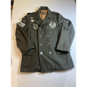 May include: Dark olive green double-breasted coat with multiple patches and buttons. The coat has a notched collar and two front pockets. Patches are on the sleeves and chest. The coat is made of a wool-like material.
