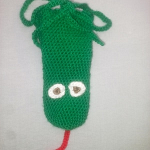 May include: A green knitted snake-shaped pouch with white and brown eyes and a red forked tongue. The pouch has a drawstring closure at the top. The snake is made of a textured yarn.