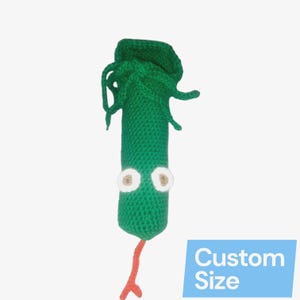 Puede incluir: Una criatura verde hecha a mano con ojos blancos y marrones y una cola roja. La criatura tiene un cuerpo texturizado y un diseño de cabeza único. El texto "Custom Size" está en un rectángulo azul.