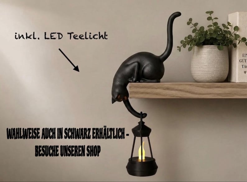 May include: A black cat figurine perched on the edge of a shelf, with its tail extending downward to hold a small black lantern containing a glowing yellow LED tea light. The text "inkl. LED Teelicht" and "WAHLWEISE AUCH IN SCHWARZ ERH&Auml;LTLICH - BESUCHE UNSEREN SHOP" is visible.
