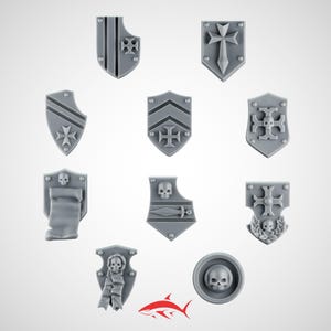 Peut inclure: Ensemble de miniatures de boucliers gris avec divers motifs : croix, rayures et crânes. Les boucliers, de formes et tailles variées, sont adaptés aux jeux de figurines ou aux projets créatifs.