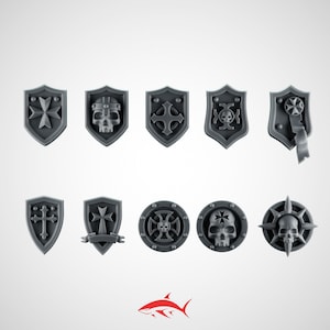 Peut inclure: Un ensemble de dix boucliers miniatures et emblèmes circulaires gris présentant des motifs en relief, notamment des croix de Malte, des crânes humains et des bannières décoratives. Ces petits composants en plastique sont disposés sur deux rangées.