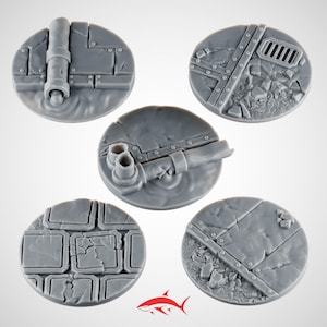 May include: Five gray, circular miniature bases with detailed textures. Each base features different industrial elements, including pipes, metal plates, and brickwork. The bases are designed for tabletop gaming miniatures.