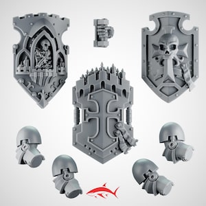 May include: A selection of grey plastic miniature shields and armour pieces, featuring gothic and religious designs. The shields display skulls, crosses, and architectural details. Includes a miniature hand holding a weapon.