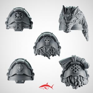 Könnte beinhalten: Fünf graue Schulterpolster-Designs mit komplizierten Details. Eines zeigt einen Wolfskopf, während andere Runen, geometrische Formen und einen Schädel zeigen. Diese Miniaturfiguren sind wahrscheinlich für Tabletop-Spiele oder den Modellbau gedacht.