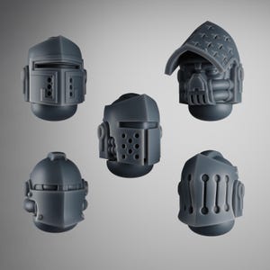 Pode incluir: Cinco modelos de capacetes cinzentos de estilo futurista. Cada capacete tem um design único, com detalhes como viseiras, aberturas e elementos decorativos. Os capacetes são provavelmente para miniaturas ou cosplay.