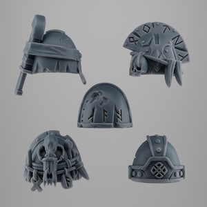 Peut inclure: Cinq composants de casque miniatures gris avec des motifs complexes. L'un a un marteau, un autre présente un crâne et des runes, et un troisième a un crâne et des détails tissés. Les deux autres ont des motifs en relief.