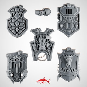 May include: A collection of gray plastic shields and a cylindrical component. The shields feature various designs, including geometric patterns, dragon motifs, and ornate details. The components are likely for miniature wargaming or model building.