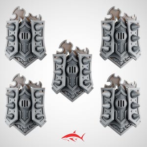 May include: Five gray miniature shields with a spiked design. Each shield has a central vertical vent, a decorative top, and a textured base. The shields are arranged in a circular pattern, with a red shark logo at the bottom.