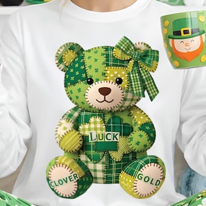 Könnte beinhalten: Ein weißes Langarmshirt und eine grüne Schlafhose mit St. Patrick's Day-Motiv. Das Shirt zeigt einen Patchwork-Teddybären mit dem Wort "LUCK". Die Schlafhose hat ein Kleeblattmuster. Eine grüne Tasse mit einem Kobold-Design wird gehalten.