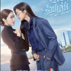 May include: A film poster with two women in a face-off. One is in a dark outfit, the other in a blue suit. The poster has Thai text and a light blue backdrop. The text includes the show's title and premiere date.