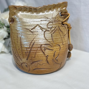 Signerad konstkeramikklocka, etsad dansande figur, beige glaserad finish
